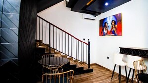 A modern interior with a staircase, a round dining table, and a bar area. - VINMILAN Hotel & Resort (Asaba)