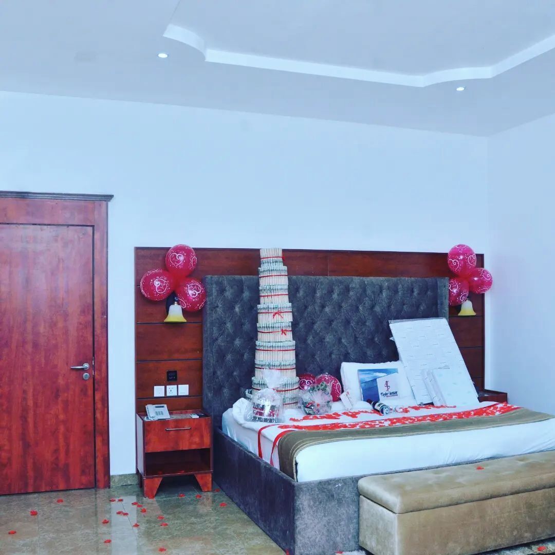 A bedroom with a bed, a wooden wardrobe, a bedside table, and a nightstand.