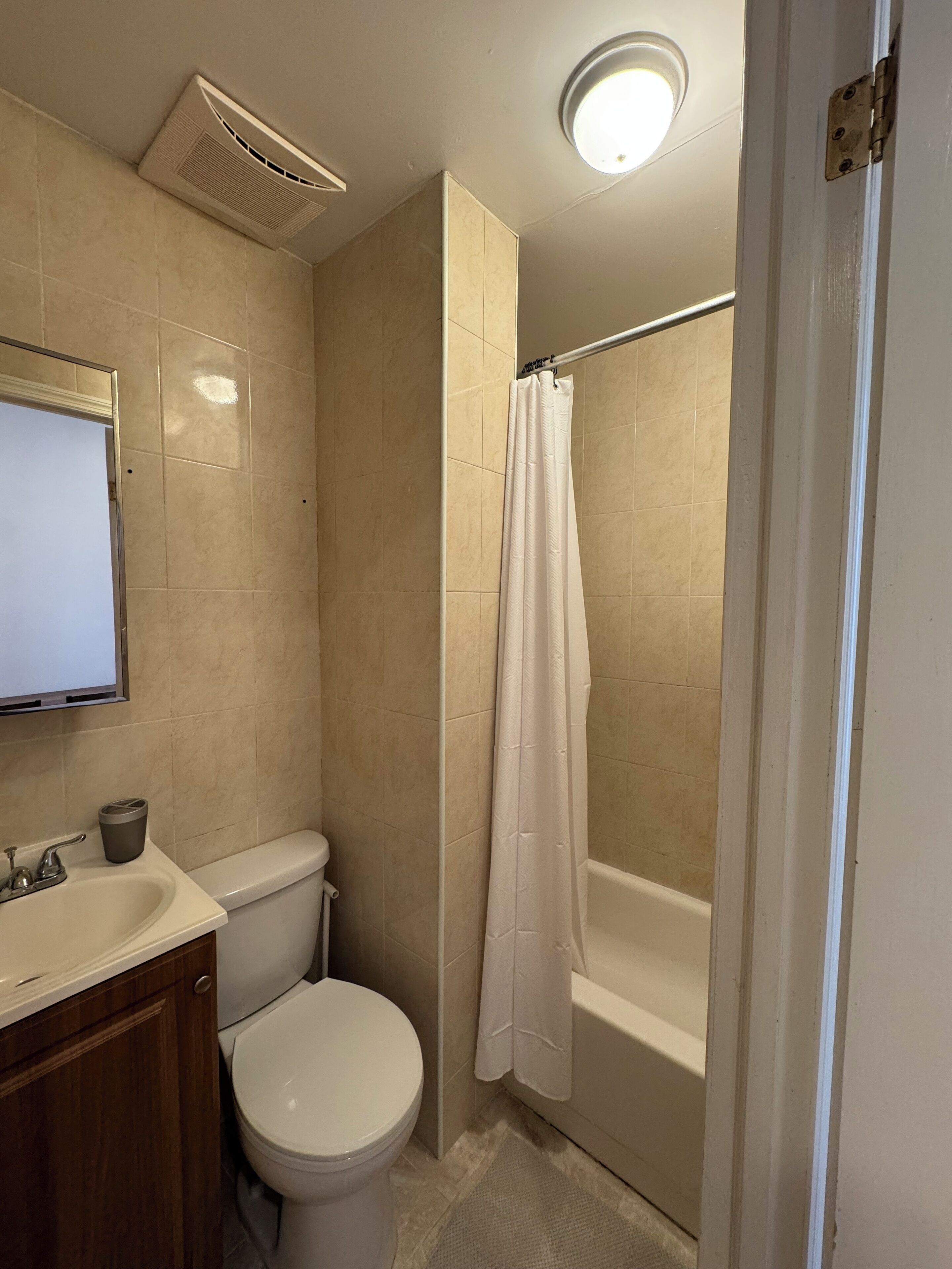 A bathroom with a toilet, sink, and bathtub.