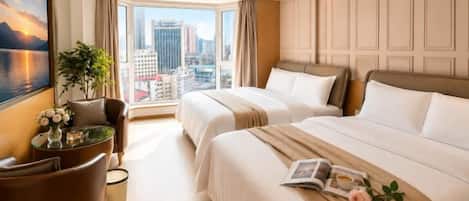 Ein Hotelzimmer mit zwei Betten, einer Sitzecke mit einem Sessel, einem kleinen Tisch und einem großen Fenster mit Blick auf die Stadt.