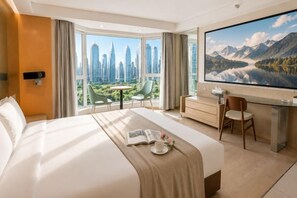 A hotel room with a large bed, a desk, a chair, a TV, and a window with a cityscape view. - Love Holiday Hotel (Dalian Zhongshan Square Railway Station) (Dalian)