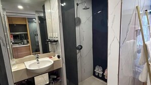 A modern bathroom with a large mirror, a sink, a shower, and a glass-enclosed shower area. - Love Holiday Hotel (Dalian Zhongshan Square Railway Station) (Dalian)