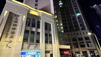 Un edificio con letreros que indican un hotel y un escaparate visible con señalización.