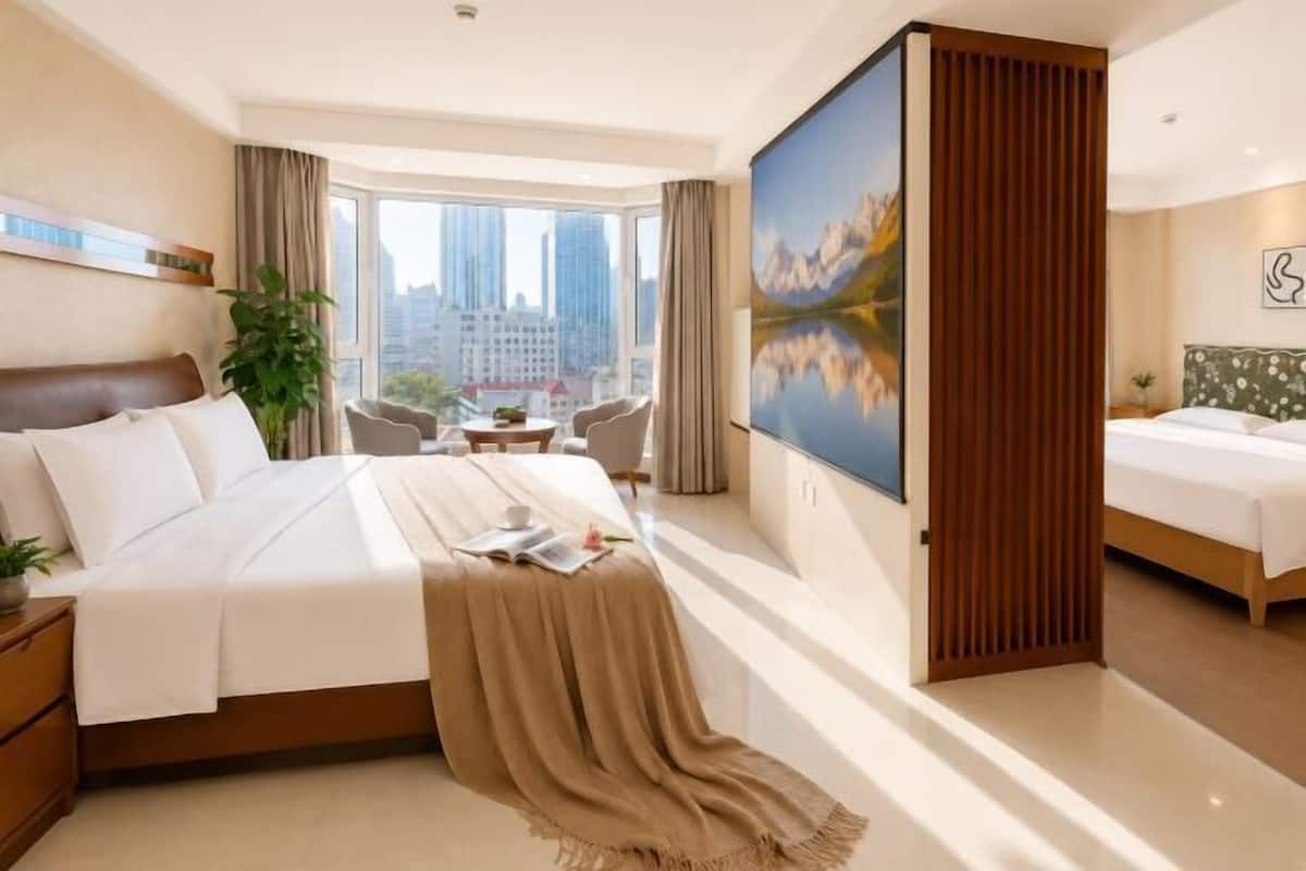 Une chambre d’hôtel avec un grand lit, un bureau, une chaise, une vue sur la ville et un grand tableau.
