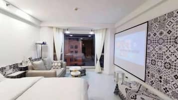 Una habitación de hotel con una cama, un sofá, una mesita y una televisión.