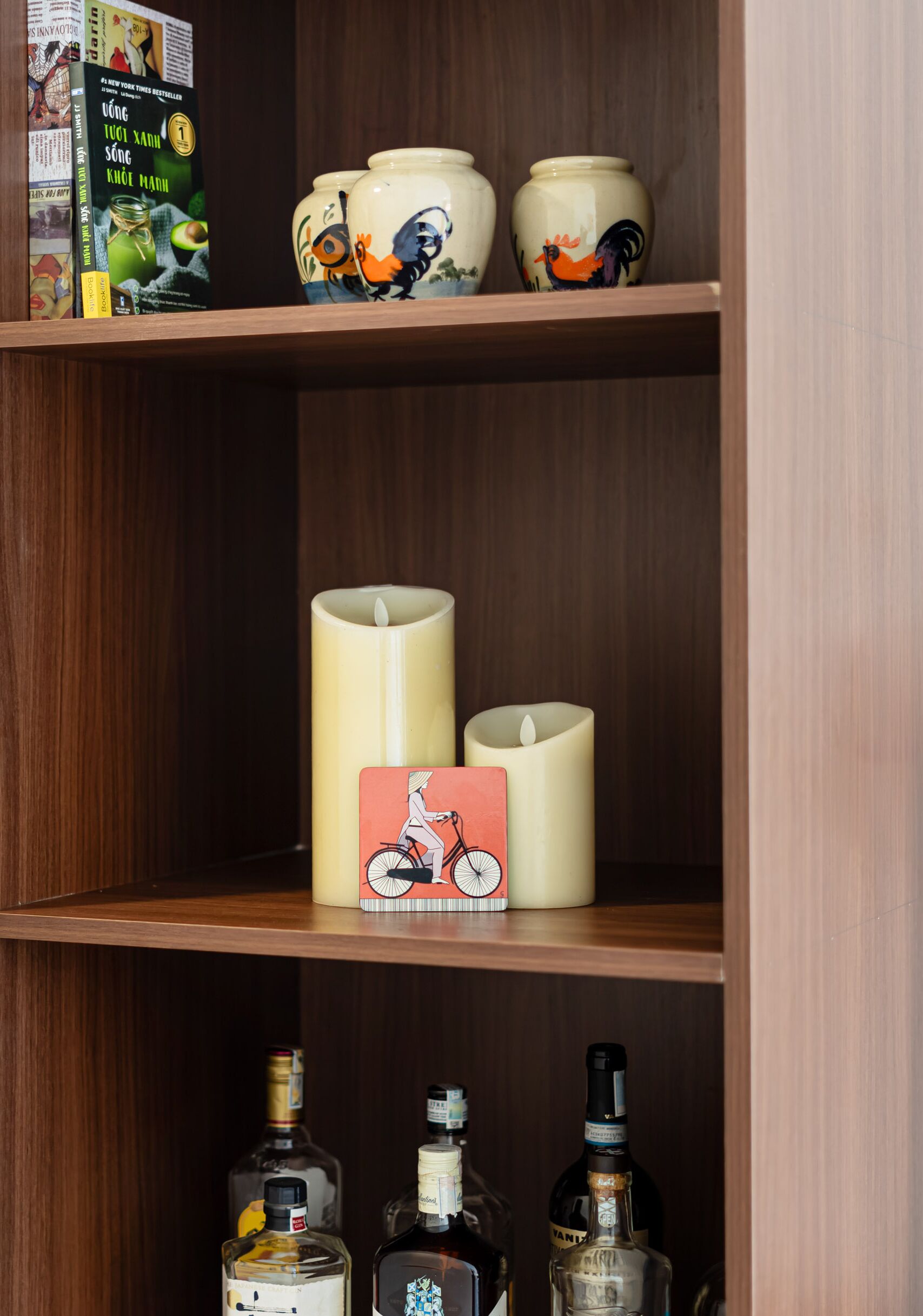 A shelf with decorative jars, candles, and books.