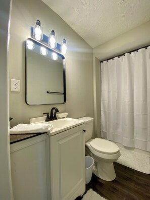 Regadera, secadora de cabello, toallas, papel de baño 
