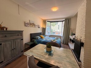 A bedroom with a bed, bedside table, and a window with curtains. - Stylish Lottus Room in Duplex Near Center & UMCG (Groningen)