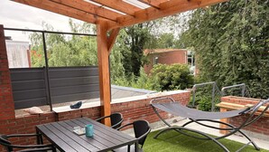 An outdoor patio with a table and chairs, a hammock, and a brick wall. - Stylish Lottus Room in Duplex Near Center & UMCG (Groningen)