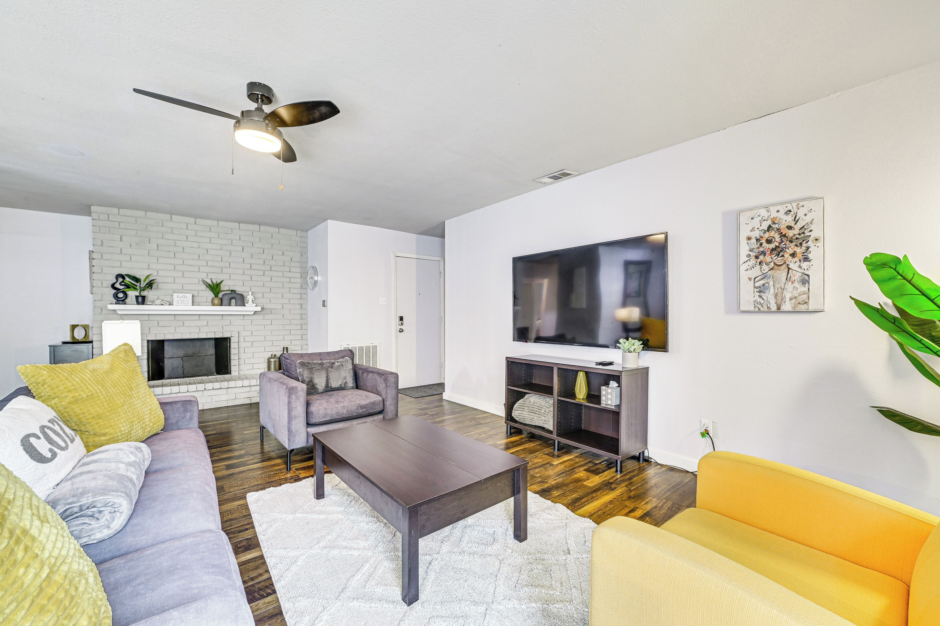 Una sala de estar moderna con chimenea, sofá, mesa de centro y televisor.