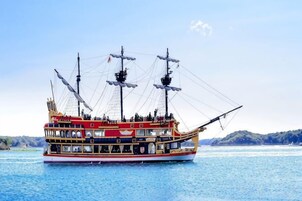 A large, multi-decked boat with multiple masts and passengers.