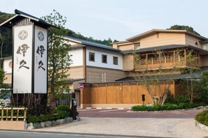 A traditional Japanese building with a wooden gate and a sign with Japanese characters.