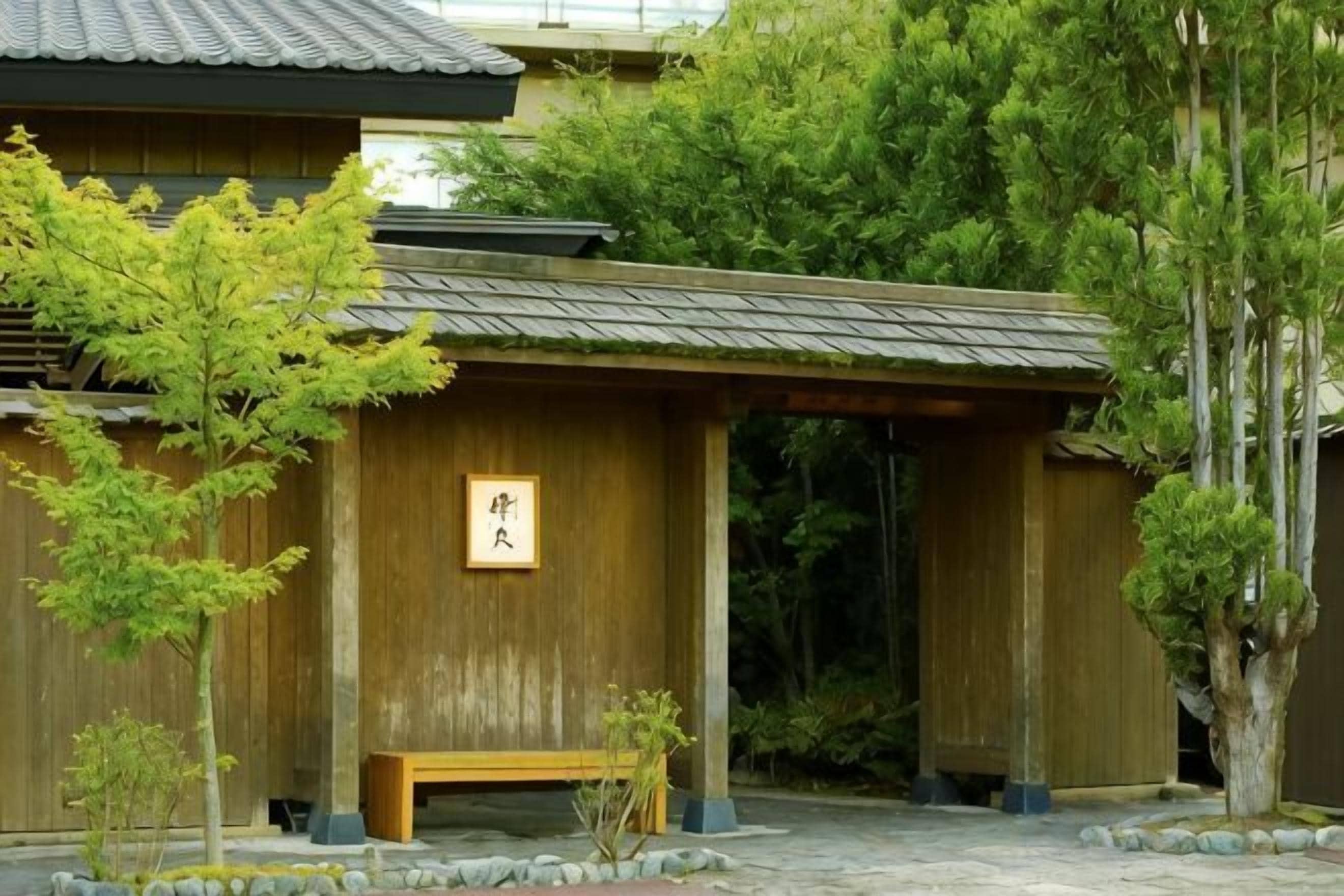 Un bâtiment traditionnel en bois, avec un banc en bois et une enseigne.