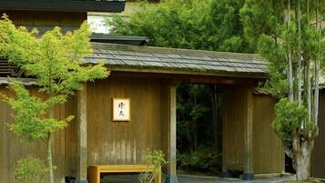 Un bâtiment traditionnel en bois, avec un banc en bois et une enseigne.