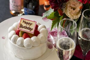 A dessert with a 'Happy Birthday' sign, surrounded by flowers and glasses of a beverage. - Inishieno yado IKYU【Reopening in April, 2026】 (Ise)