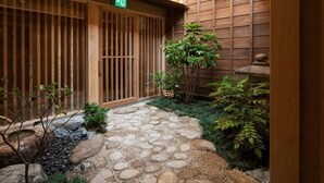 A traditional Japanese-style courtyard with a stone pathway, wooden gates, and potted plants. - Inishieno yado IKYU【Reopening in April, 2026】 (Ise)