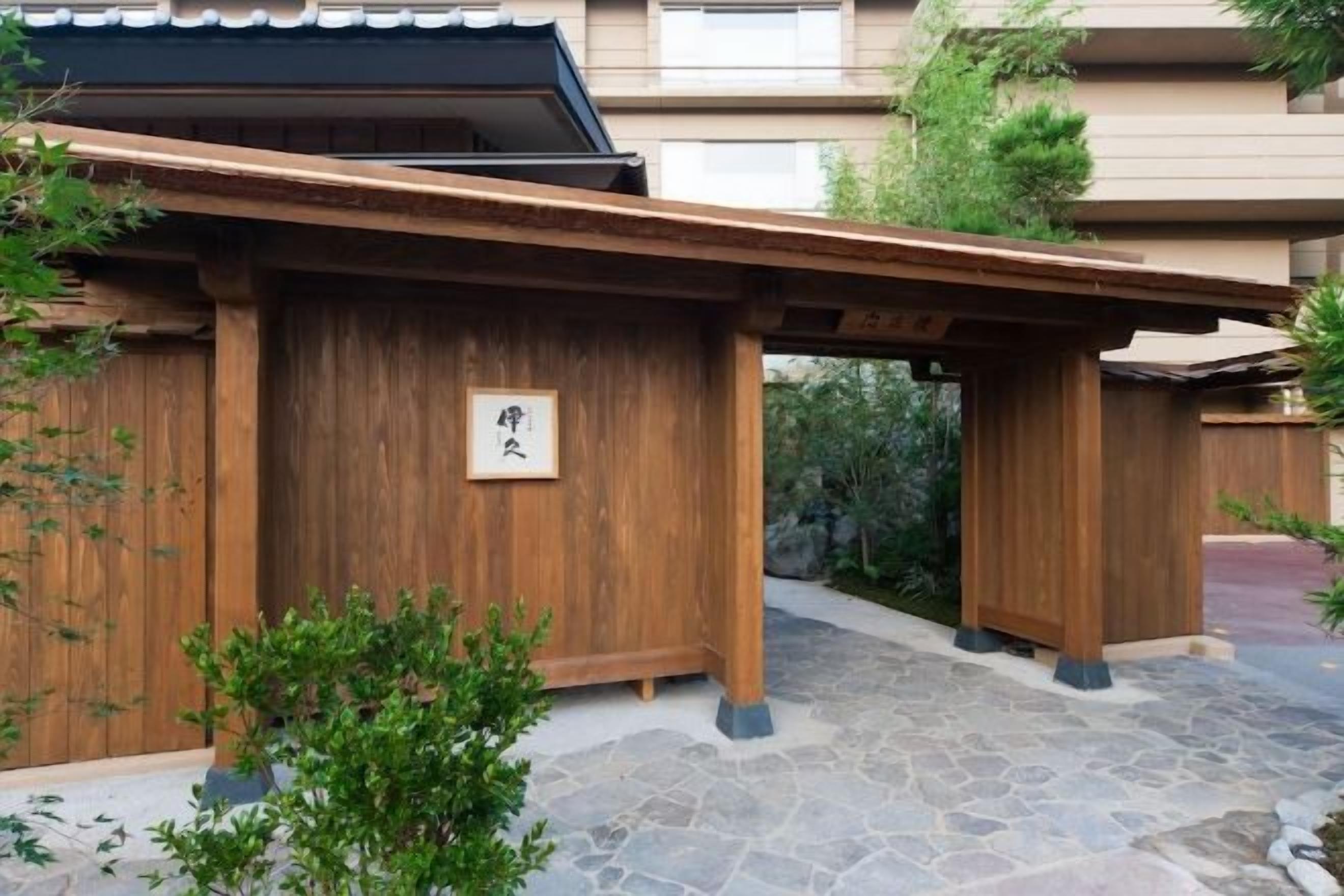 Ein traditionelles japanisches Gebäude mit Holzbauweise und einem eingangsbepflasterten Vorbereich.