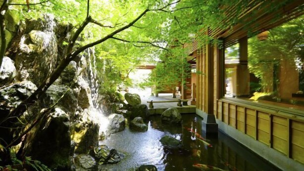 A traditional Japanese garden with a koi pond, wooden walkways, and a stone bridge. - Inishieno yado IKYU【Reopening in April, 2026】 (Ise)