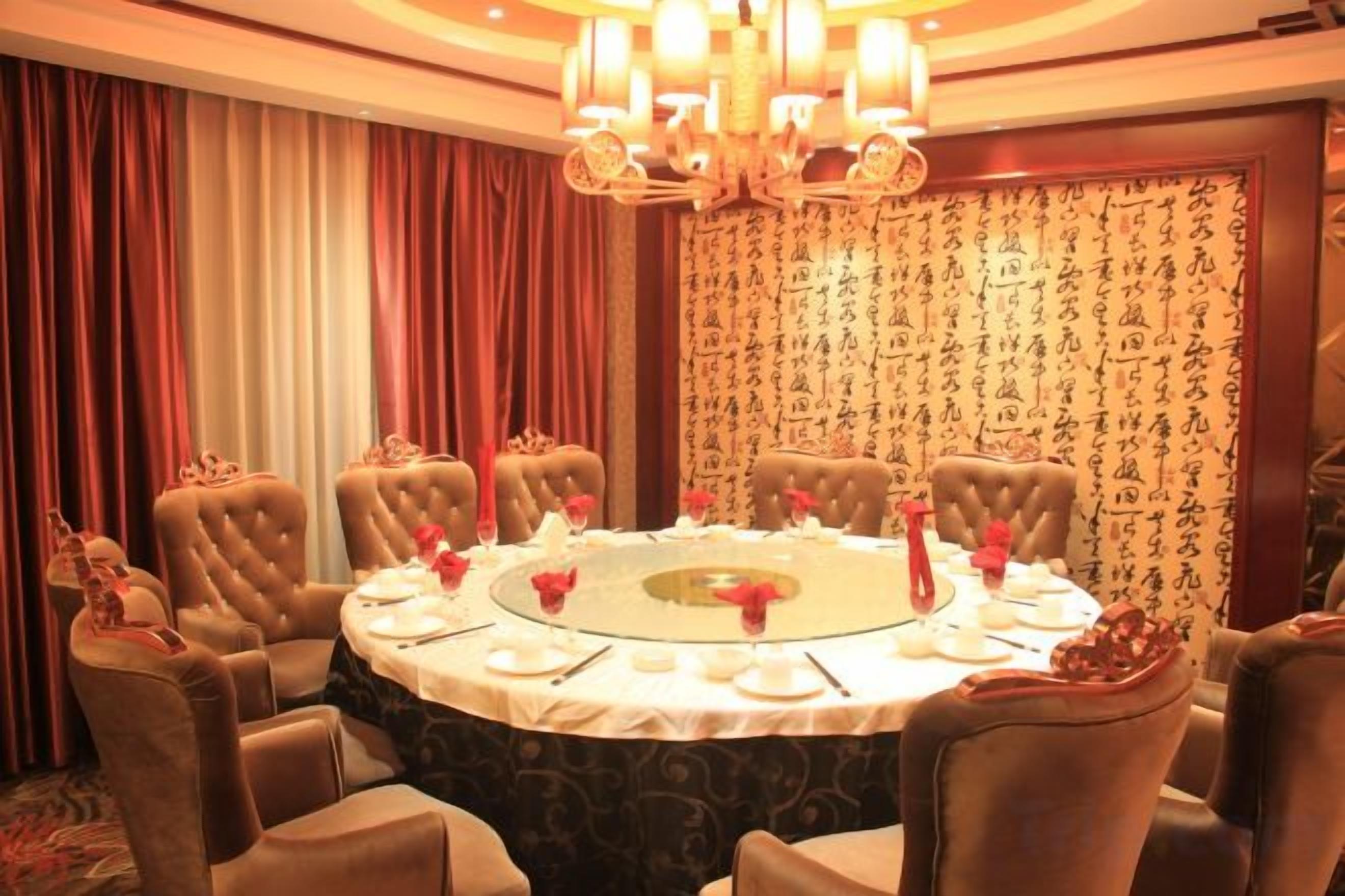 A conference room with a round table, chairs, and a chandelier.