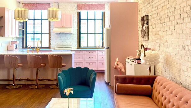 A modern living room with a marble coffee table, a teal armchair, and a pink sofa. - NEW luxury retro loft in heart of historic, walkable Southside district  (Chattanooga)