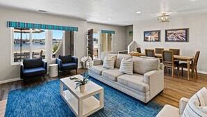 A living room with a sofa, chairs, a coffee table, and a dining area with a table and chairs.