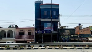 A multi-story building with a prominent water tower, surrounded by various commercial establishments. - Hanumat Home Stay (Faizabad)