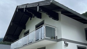 A two-story building with a balcony, large windows, and a modern architectural design.