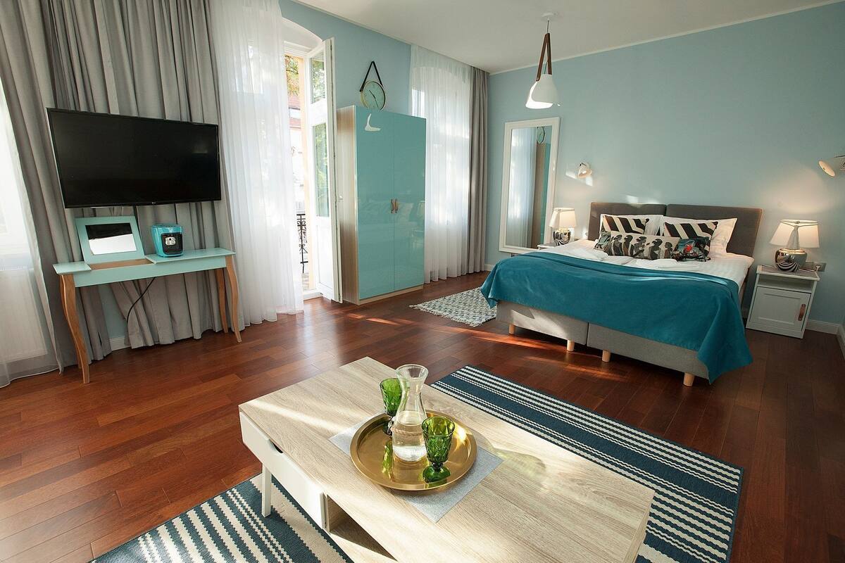 Une chambre d’hôtel moderne équipée d’un lit, d’une télévision, d’un bureau et d’une table basse.