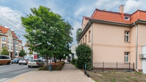 A residential street with houses, a sidewalk, and parked cars. - Comfort Art by Grand Apartments (Sopot)