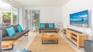 Ein modernes Wohnzimmer mit Sofa, Couchtisch und TV-Schrank.