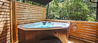 Serene riverfront cabin in North GA with a hot tub, fire pit, porch swing & movie loft.