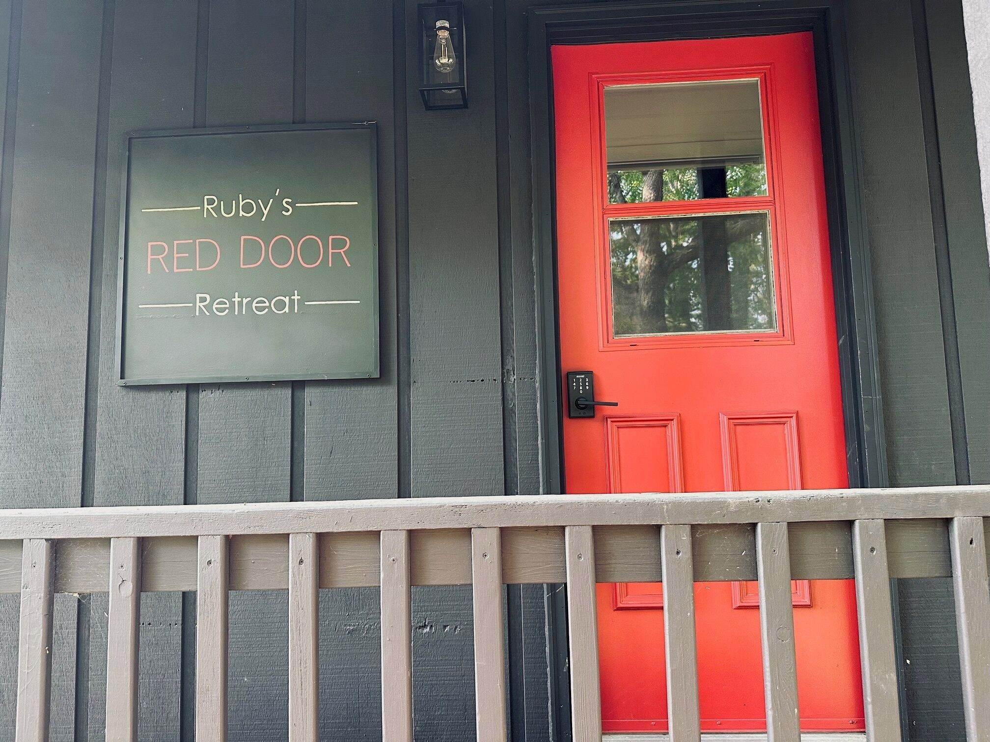 A red door with a sign above it that reads "Ruby's Red Door Retreat."
