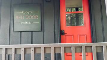A red door with a sign above it that reads "Ruby's Red Door Retreat."