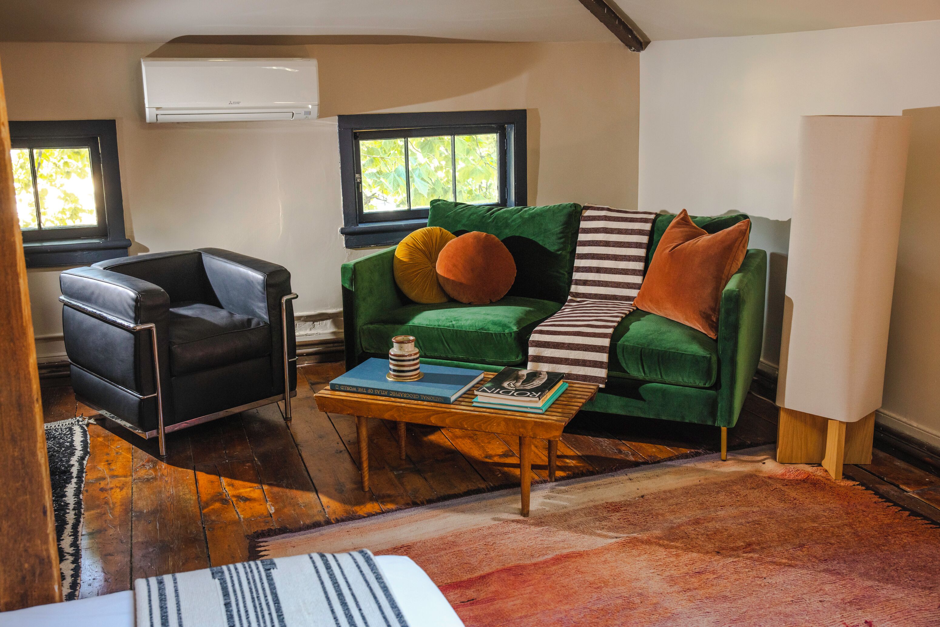 A living room with a green sofa, a black armchair, and a wooden coffee table.