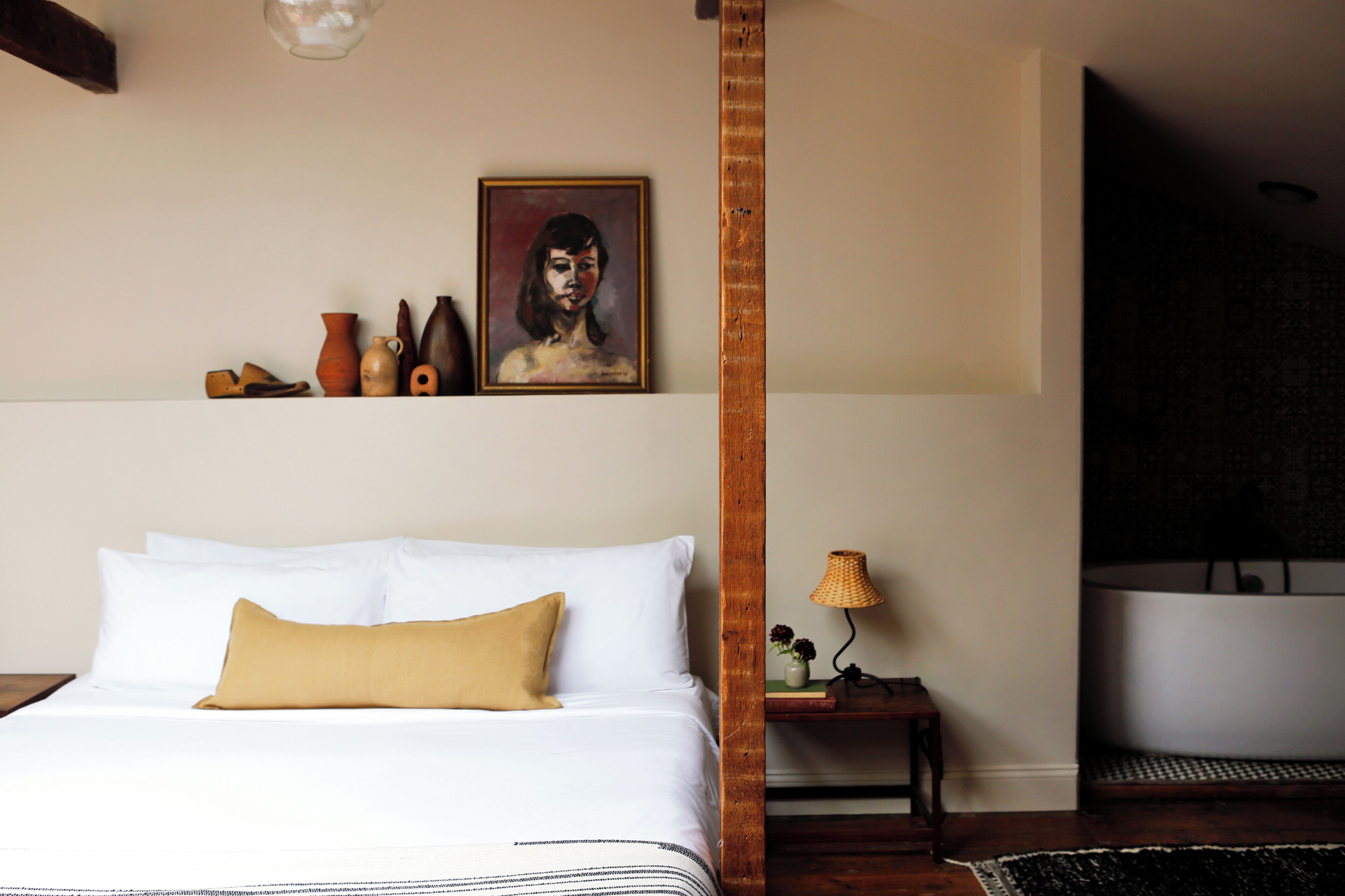 Una habitación de hotel con una cama, un cuadro y una bañera.
