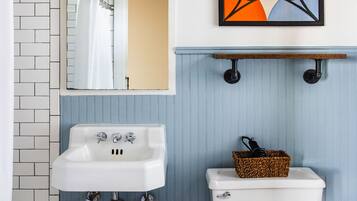 A bathroom with a white sink, a toilet, and a shower.