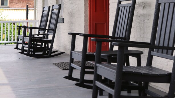A covered porch with rocking chairs and a red door. - Kingston Carriage House (Kingston)