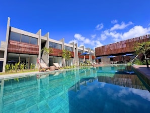 A modern hotel with a large pool, outdoor seating, and a clear blue sky. - Flat super luxo em Japaratinga - Alagoas (Japaratinga)
