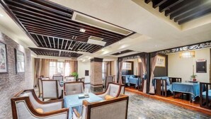 Un comedor de hotel con cabinas y mesas, piso de mármol y techo decorativo.