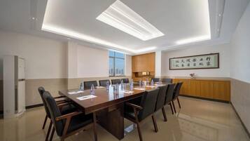 A conference room with a long table, chairs, and a ceiling light fixture.