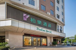 A hotel with a prominent entrance, signage in two languages, and a clear view of the building's facade. - Parlor Hotel (Dongguan)