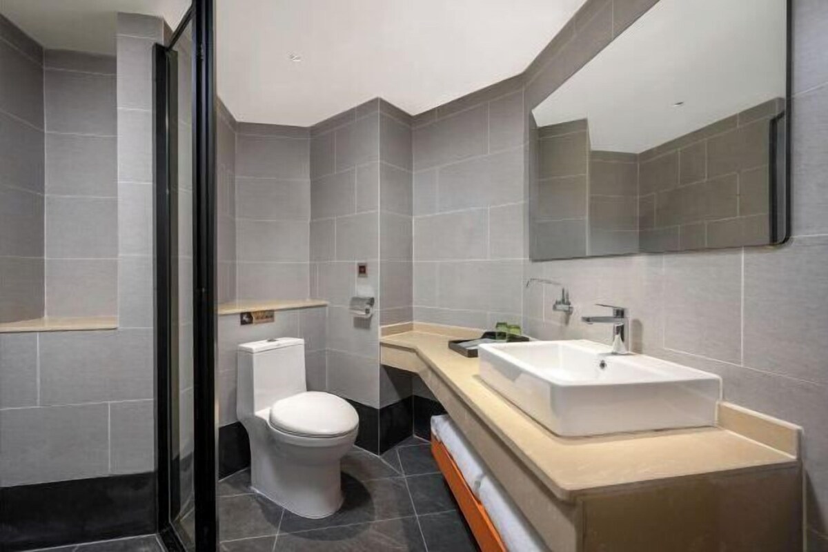 Un baño moderno con inodoro, lavabo y espejo.