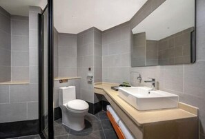 Un baño moderno con inodoro, lavabo y espejo.