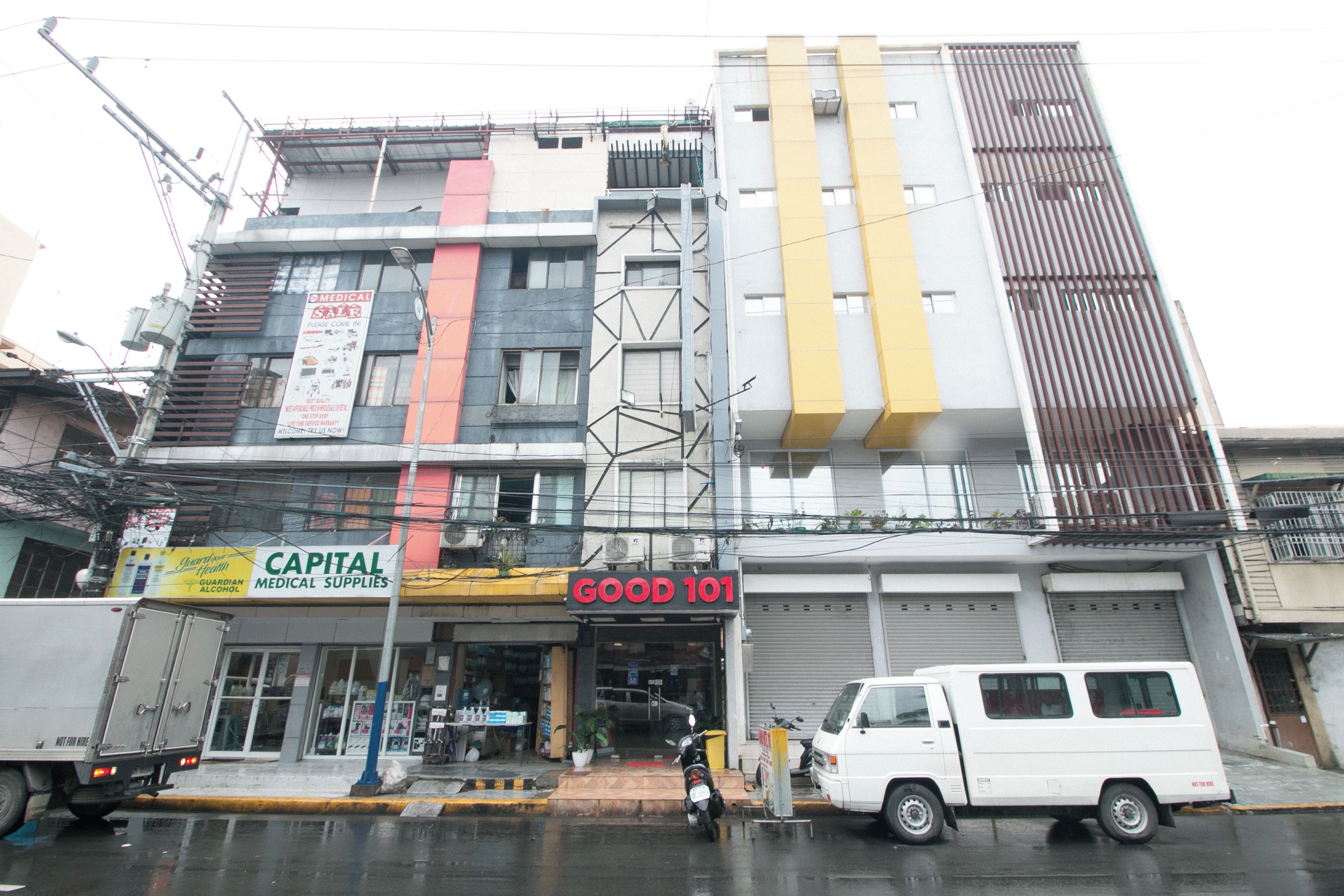 Un edificio a più piani con diversi negozi, tra cui un negozio di articoli sanitari e una farmacia.