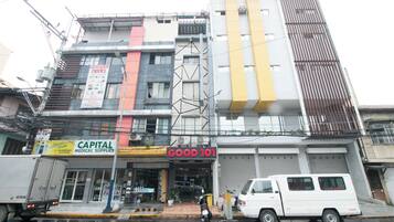 Un edificio a più piani con diversi negozi, tra cui un negozio di articoli sanitari e una farmacia.