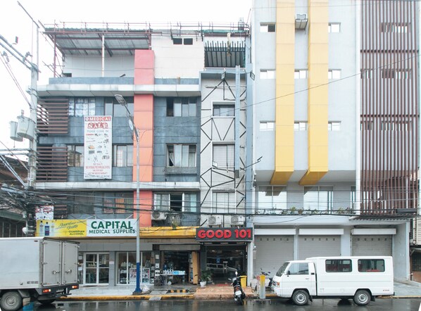 A multi-story building with various commercial establishments, including a medical supplies store and a food service. - Reddoorz @ Good 101 Quiricada Manila (Manila)