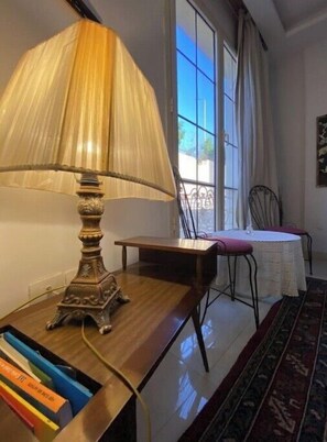 Work in comfort with a traditional desk and chair, paired with a classic table lamp and a view of the outdoors.