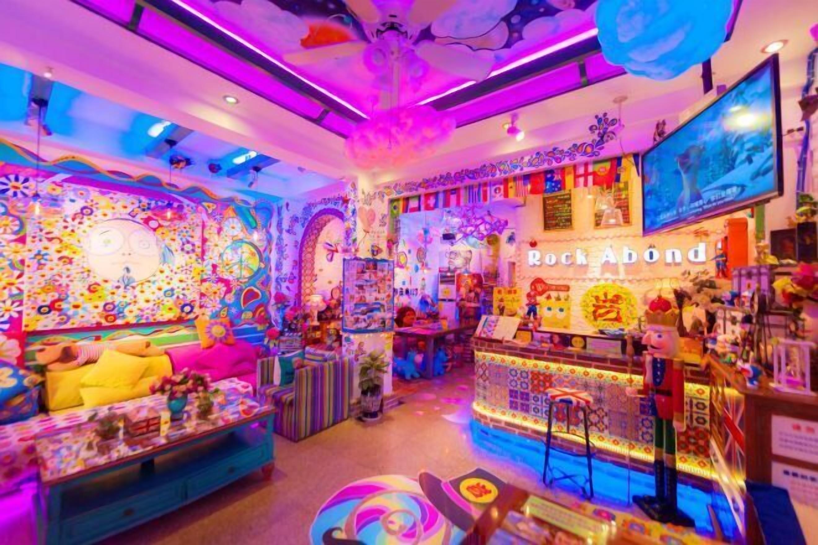 Um quarto vibrante e colorido, com um design divertido, que apresenta um sofá, uma mesa com vários objetos e um balcão com produtos à venda.