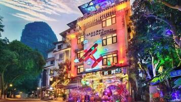 Um edifício bem iluminado com sinalização colorida e uma estrutura em forma de X destacada na fachada.