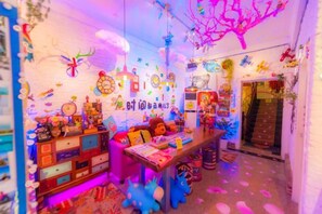 A brightly decorated room with a desk, shelves, and various items. - Yanbang·Fantasy Art Designer Homestay (West Street) (Yangshuo)